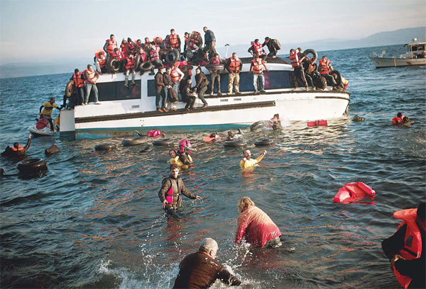 Refugees and migrants react as their boat sinks off the Greek island of Lesbos after crossing the Aegean Sea from Turkey on Oct 30. (AFP)