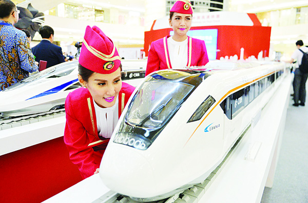 In this photo taken on Aug 13, 2015, Indonesian models look at scale models of Chinese-made bullet trains on exhibition at a shopping mall in Jakarta. Chinese and Indonesian state-owned companies on Oct 16 signed a $5.5 billion deal to build the first high-speed railway in Southeast Asia’s top economy, after Beijing beat Tokyo to win the construction project. (AFP)