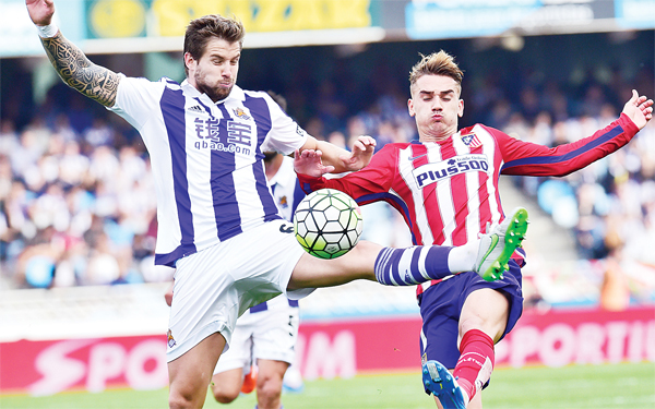 Atletico de Madrid’s Antoine Griezmann (right), duels for the ball with Real Sociedad’s Inigo Martinez, during their Spanish La Liga soccer match, at Anoeta Stadium in San Sebastian, northern Spain, Oct 18. (AP)