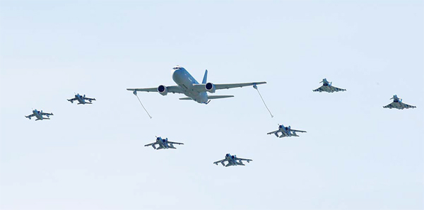 A Boeing KC-767 aerial refueling and strategic transport aircraft (center), flies along jet fighters during NATO Trident Juncture exercise 2015, in Trapani, Italy