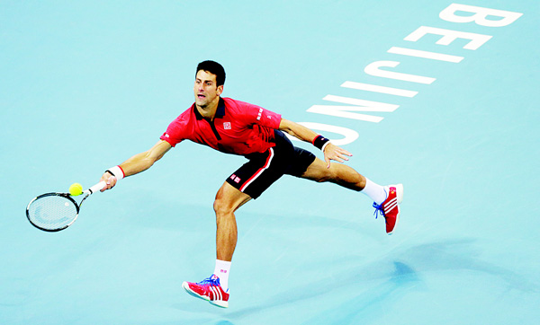 Novak Djokovic of Serbia reaches for the ball as he plays against Rafael Nadal of Spain during their men’s singles final match in the China Open tennis tournament at the National Tennis Stadium in Beijing.
