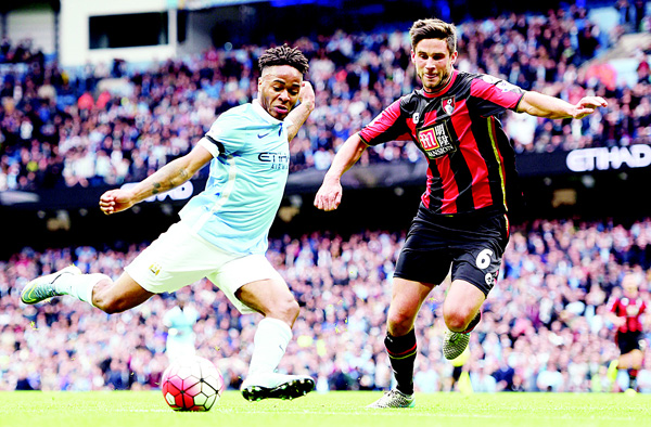 Manchester City’s Raheem Sterling (left), scores his side’s fourth goal of the game to complete his hat-trick, past Bournemouth’s Andrew Surman, during their English Premier League soccer match at The Etihad Stadium, Manchester, England on Oct 17. (AP)