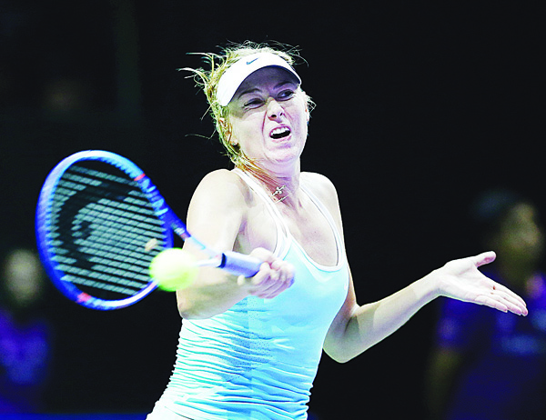 Maria Sharapova of Russia makes a forehand return against Simona Halep of Romania during their singles match at the WTA tennis finals in Singapore on Oct 27. (AP)