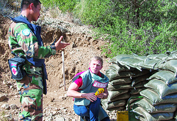 In this photo released by the United Nations in Cyprus (UNFICYP) on Oct 13, the British actor Daniel Craig speaks with a UN specialist mine detecting team member at the minefields in the UN controlled buffer zone on the divided island of Cyprus. (AP)