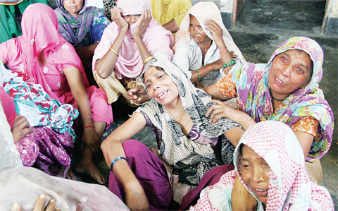 Relatives of victims of an arson assault on a family home mourn following the attack in Faridabad on Oct 20. (Inset): Men look through a window into the burnt remains of a room. (AFP)