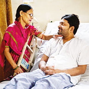 Pushplata Sharma (left), mother of Tejaswi Sharma, a 34-year-old software engineer, talks to her son who is recovering from a very fatal stage of dengue at Holy Family hospital in New Delhi, India. (AP)