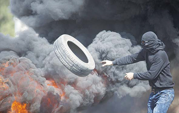 Palestinians burn tires during clashes with Israeli troops near Ramallah, West Bank on Oct 16. Tensions and violence have been mounting in recent weeks, in part fueled by Palestinian fears that Israel is trying to expand its presence at a major Muslim-run shrine in Jerusalem, a claim Israel has denied. (AP)