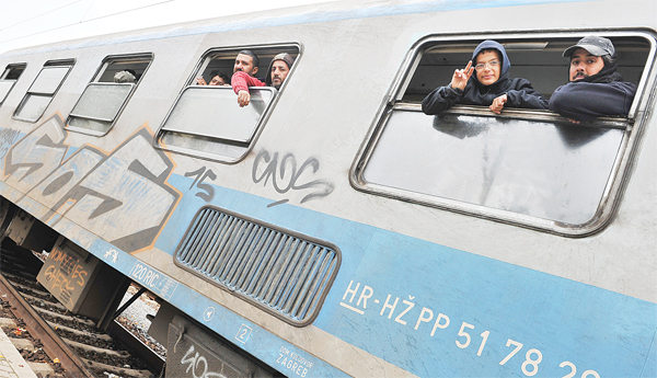 Migrants and asylum seekers wait aboard a train in the eastern Croatian town of Tovarnik on Oct 21, on their way to the border with Slovenia from where they plan to continue their journey to western European countries.