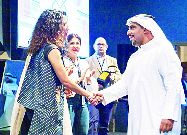 Dari Al-Reshaid on stage with Hussa Al-Humaidi while thanking Alghanim Industries.