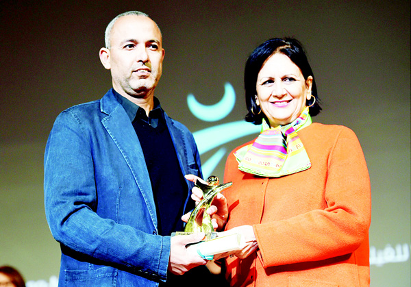 Moroccan director Mohamed Mouftakir (left), receives from Tunisian Culture Minister Latifa Lakhdar the Golden Tanit award for his film ‘L’orchestre des Aveugles’ during the closing ceremony of the 26th Carthage Film Festival on Nov 28, in the Tunisian capital Tunis. (AFP)