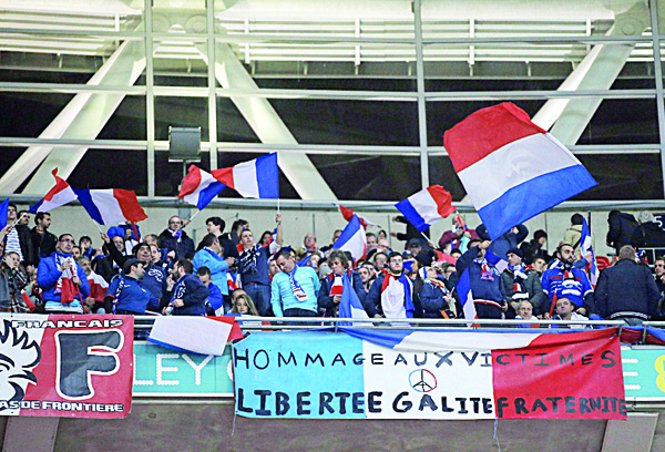 Football fans wave French flags before the start of the friendly football match between England and France at Wembley Stadium in West Londan on Nov 17. (AFP)