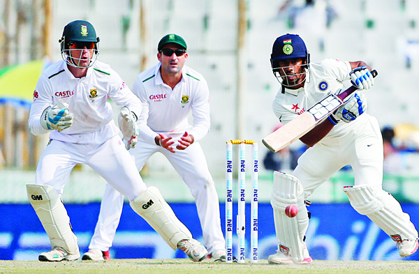 India’s Wriddhiman Saha (right), bats with South African wicketkeeper Dane Vilas (left), and Dean Elgar fielding during the third day of their first cricket Test match in Mohali, India on Nov 7. (AP)