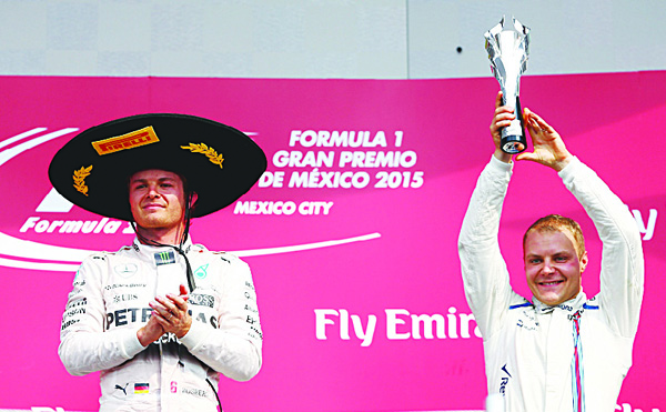 Valtteri Bottas of Finland and Williams celebrates on the podium next to Nico Rosberg of Germany and Mercedes GP after finishing third in the Formula One Grand Prix of Mexico at Autodromo Hermanos Rodriguez on Nov 1 in Mexico City, Mexico. (AFP)