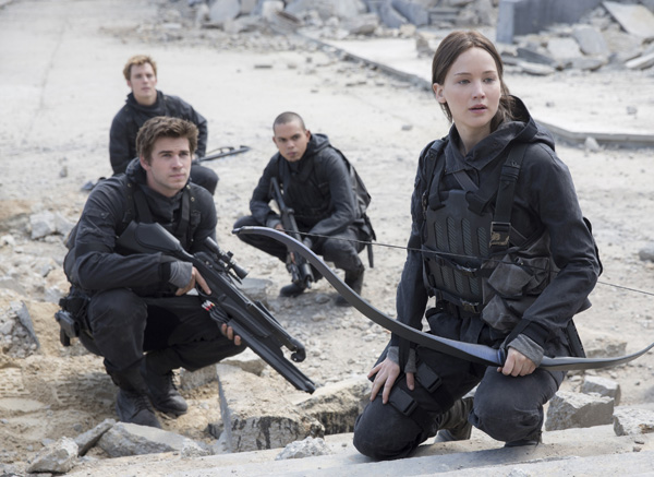 This photo provided by Lionsgate shows, Liam Hemsworth, left, as Gale Hawthorne, Sam Clafin, back left, as Finnick Odair, Evan Ross, back right, as Messalia, and Jennifer Lawrence, right, as Katniss Everdeen, in the film,