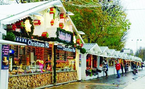 People walk past a food stand on the reopening day of the Paris Christmas market on the Champs-Elysees avenue on Nov 19. (AFP)