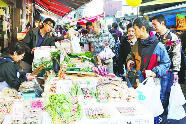 Shoppers choose vegetables at a market in Tokyo on November 27, 2015. Japanese consumer prices fell 0.1 percent in October year-on-year, official data showed on November 27, as the government mulls ways to safeguard its fragile economy.