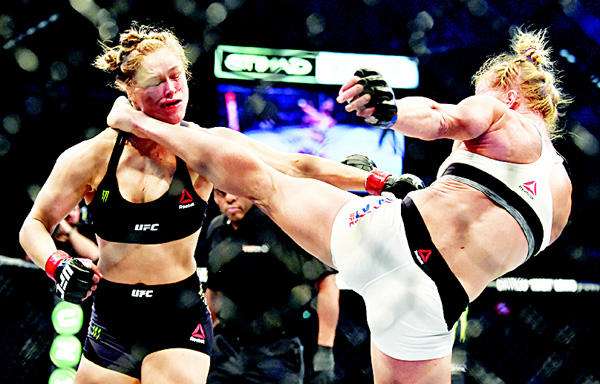 Holly Holm of the US (right), lands a kick to the neck to knock out compatriot Rousey and win the UFC title fight in Melbourne on Nov 15. (AFP)
