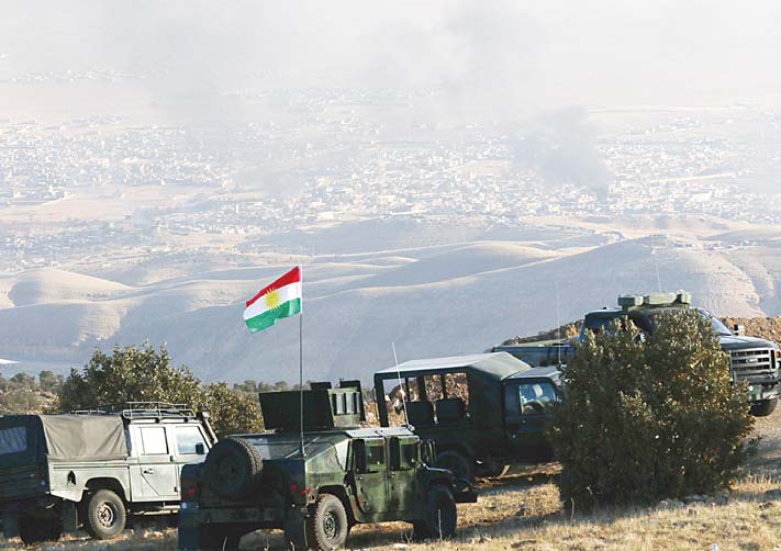 Iraqi Kurdish forces are seen stationed on a hilltop as smoke billows during an operation by Iraqi Kurdish forces backed by US-led strikes in the northern Iraqi town of Sinjar on Nov 12, to retake the town from the Islamic State group and cut a key supply line to Syria. (AFP)
