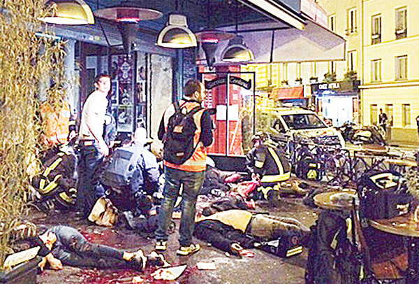 Victims of a shooting attack lie on the pavement outside La Bell Equipe restaurant in Paris on Nov 13. Well over 129 people were killed in Paris on Friday night in a series of shootings, explosions. (AP