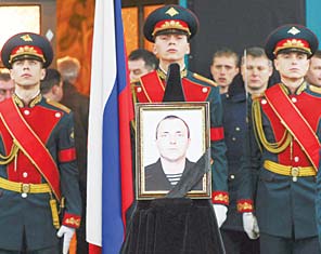 A honour guard holds a portrait of Alexander Pozynich, a marine killed in Syria when he was on board of a downed helicopter while taking part in rescue operation of Russian pilots on Nov 17, during his farewell ceremony in Novocherkassk, Rostov region, south Russia,