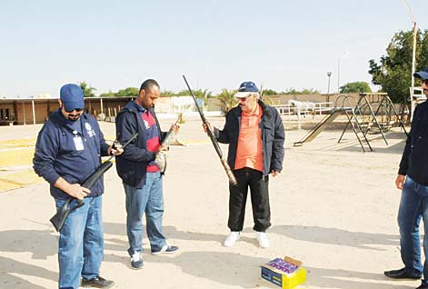 CID personnel inspecting the seized weapons