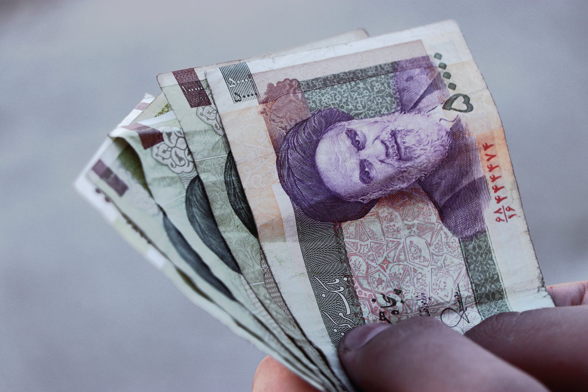 person holding rial bills
